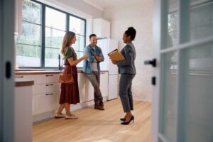 A family tours a bright, open living room with an agent, examining features and discussing home details.